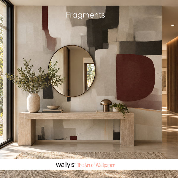Abstract mural with beige, gray, charcoal and burgundy blocks behind a wooden console.