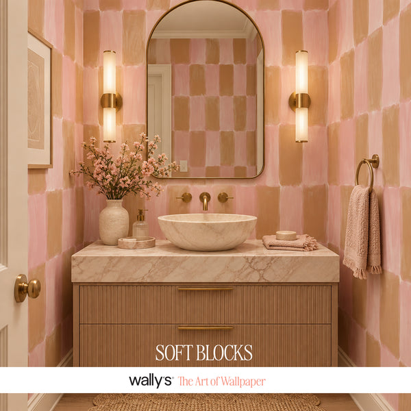 A styled bathroom interior featuring pink and peach watercolor-style wallpaper blocks, a marble countertop with a vessel sink, wall-mounted light fixtures, a mirror, and a towel ring. The text 'SOFT BLOCKS' and 'wallys The Art of Wallpaper' appear at the bottom.