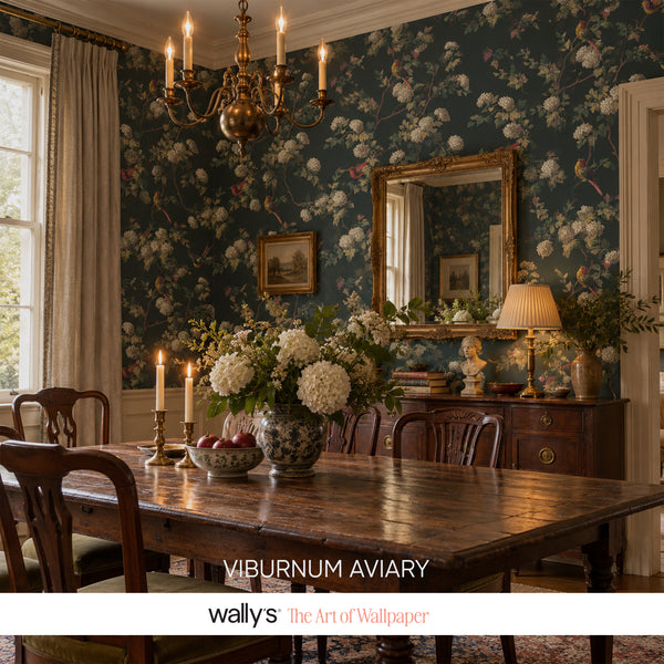 Dining room with dark teal Viburnum Aviary wallpaper, brass chandelier and gold mirror.