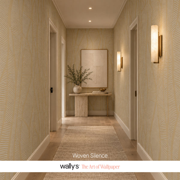 A long hallway with beige wallpaper featuring a subtle woven leaf pattern, a light wood console table with a vase of branches, a large framed artwork on the wall, and two vertical wall sconces. Text at the bottom reads 'Woven Silence' and 'wally's The Art of Wallpaper'.